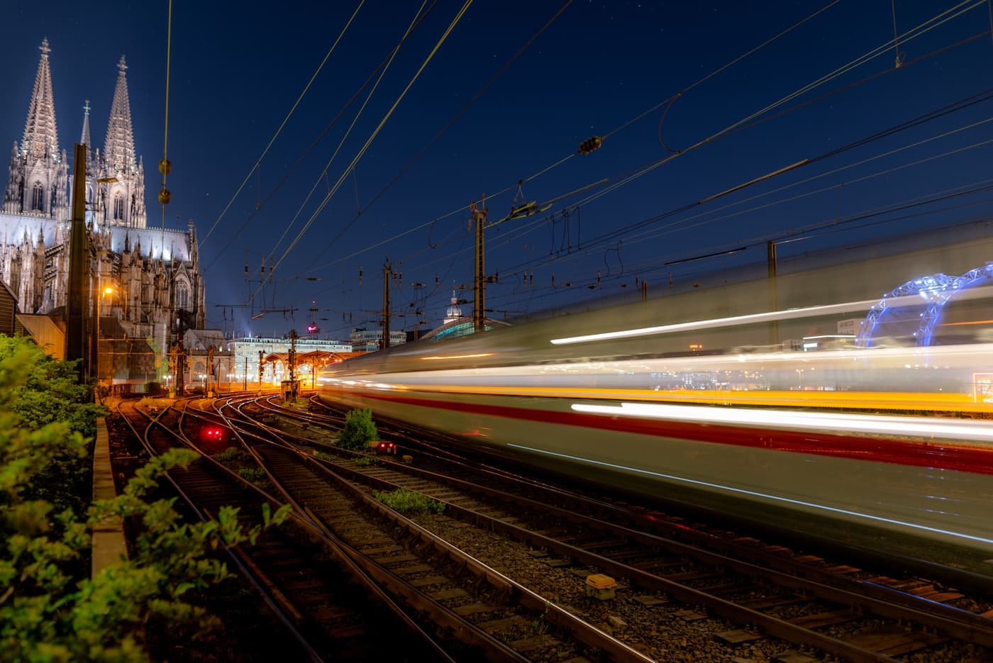 A night train streaking past a lit cathedral